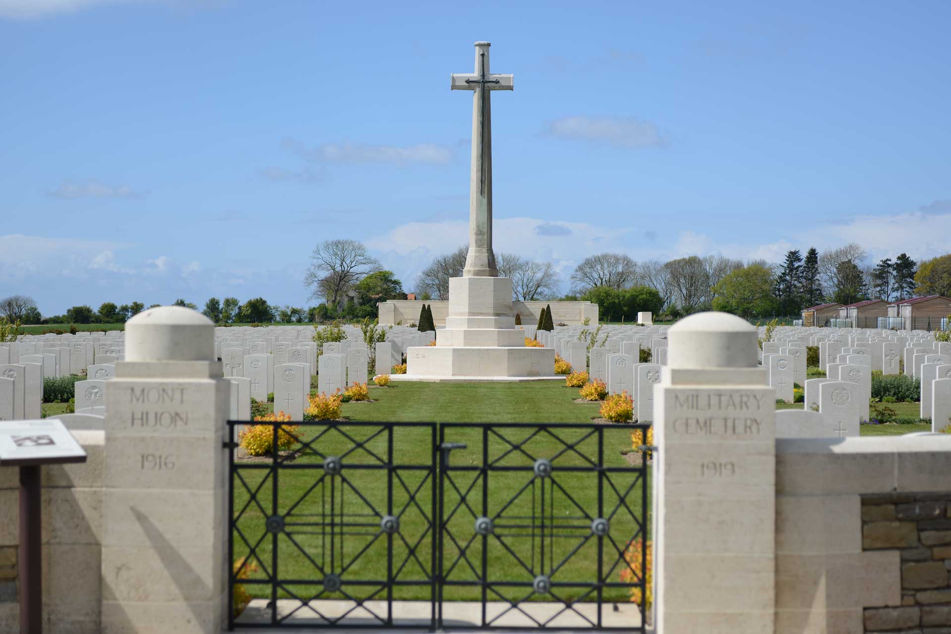 British military cemetery in Northern France (Huon), showing entrance gates and central stone cross.