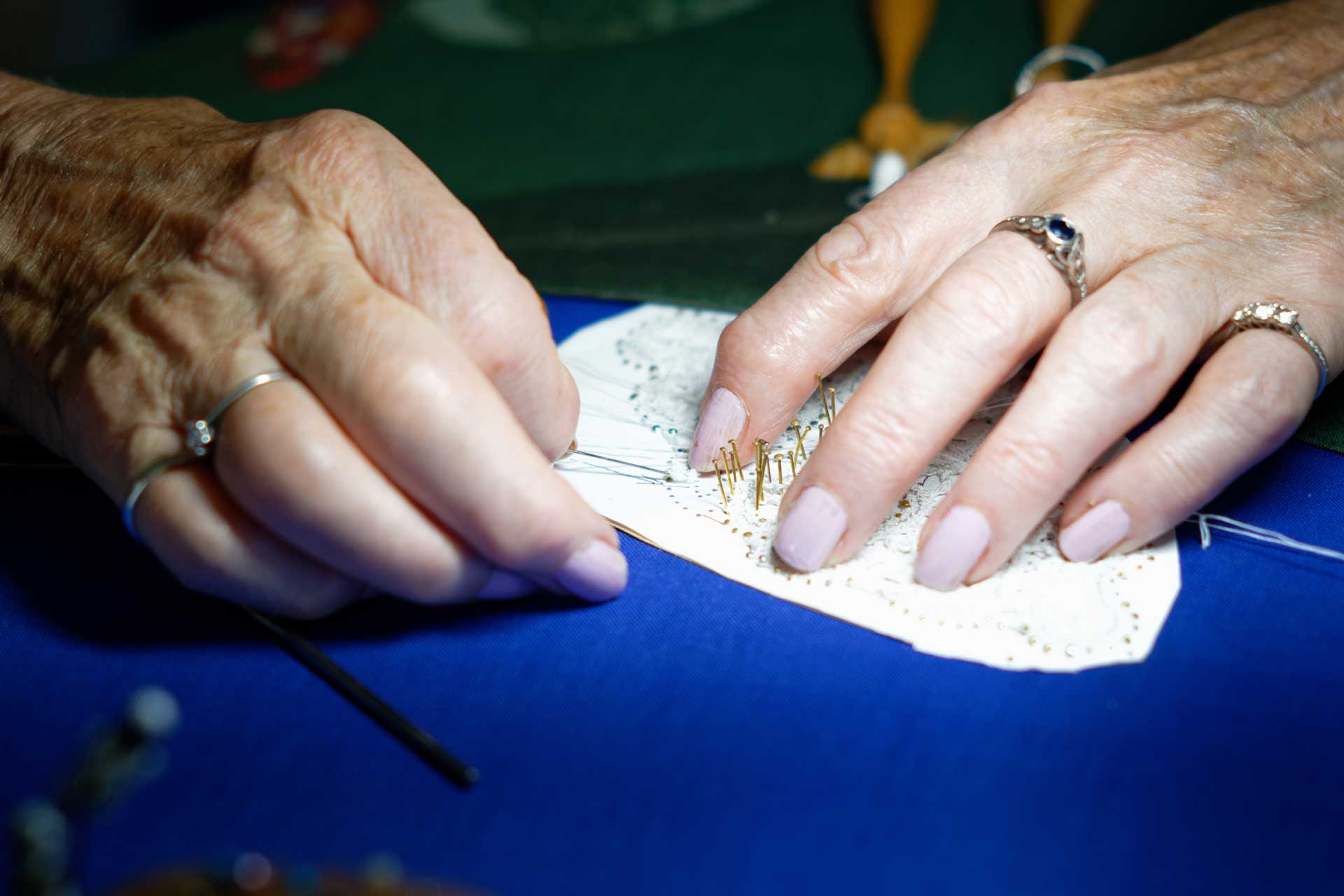 Close-up picture of two elderly lady's hands making lace.