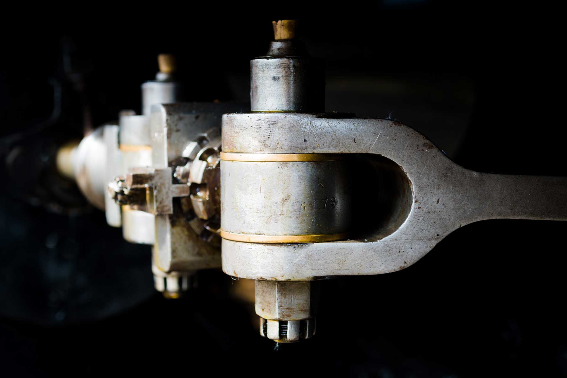 Close-up of a 1920s mainline steam locomotive's valve gear, showing internal to external connecting link.