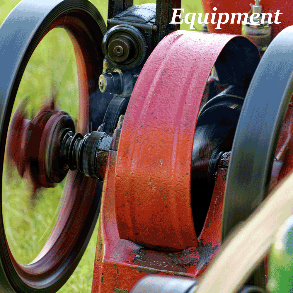 An old fashioned running petrol engined machine, spinning fast, with a drive belt.