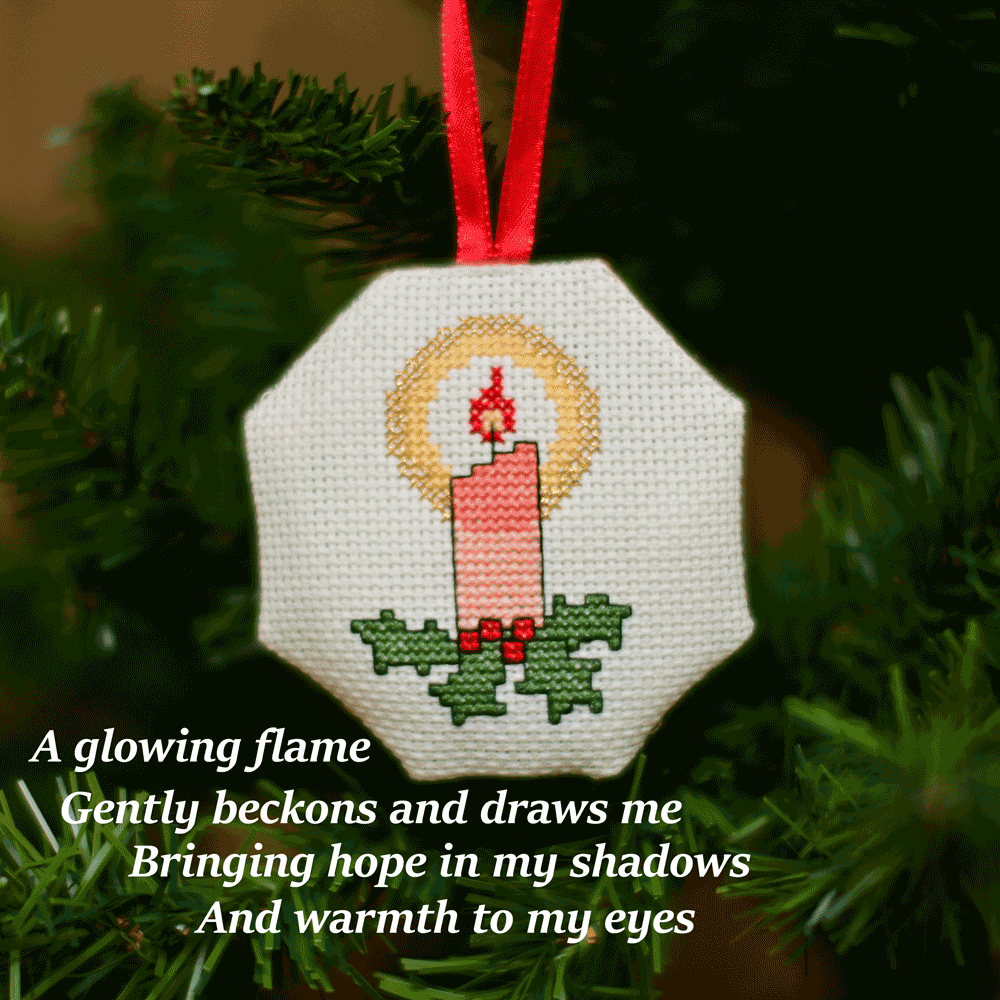 Cross-stitched octagonal picture of a lit candle, hanging in a Christmas tree.